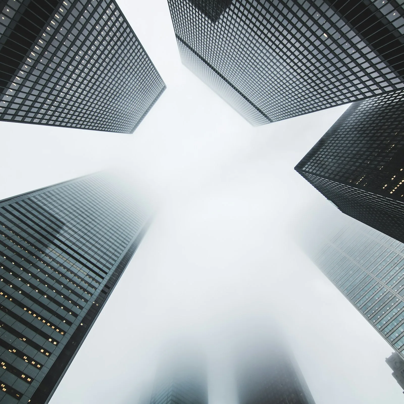 Modern office towers photographed from street level against a bright sky
